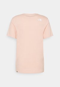 Světle růžové bavlněné tričko s krátkým rukávem a kulatým výstřihem. Na zadní straně se nachází malé bílé logo ve středu nahoře.