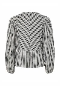Blusa a scacchi bianco e nero con maniche a sbuffo, vita a peplum e tessuto testurizzato caratterizzato da motivi diagonali e a griglia.