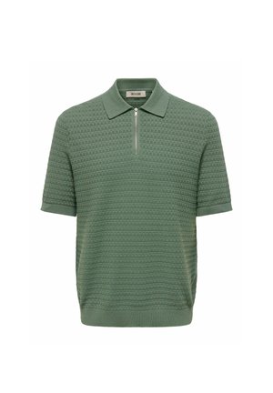 Polo vert en maille à manches courtes avec motif texturé et fermeture éclair à l'avant sous le col.
