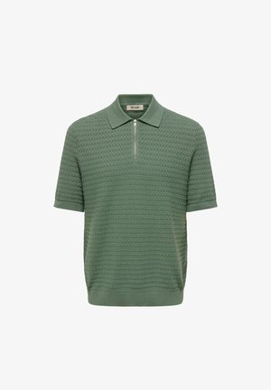 Polo vert en maille à manches courtes avec motif texturé et fermeture éclair à l'avant sous le col.