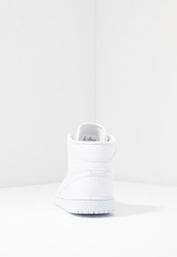 Zapatilla alta blanca hecha de cuero texturizado con un acabado suave, que cuenta con un collar acolchado y suela de goma. Sin patrones ni acentos visibles.