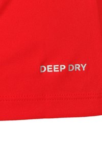 Prenda roja con una textura suave y un dobladillo cosido. El texto “DEEP DRY” aparece en plata, orientado horizontalmente cerca de la parte inferior.