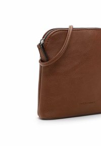 Sac à main en cuir marron avec une finition texturée, fermeture éclair et profil mince. Dispose d'une bandoulière amovible pour des options de transport polyvalentes.