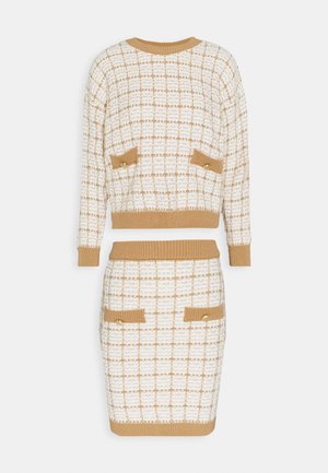 Ensemble tricot deux pièces avec motif à carreaux beige et blanc, top à manches longues et jupe longueur genou, avec détails de poches assorties munies de boutons.