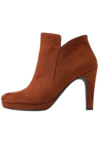 Stivale alla caviglia in suede marrone con punta rotonda, tacco alto e un design a ritaglio unico. Presenta dettagli di cucitura e una texture liscia.