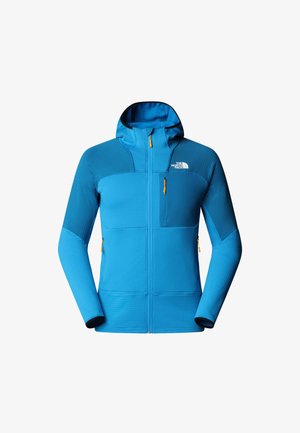 Blauwe jas van luxe stof met een rits aan de voorkant, verstelbare capuchon en contrasterende donkerblauwe panelen. Voorzien van ritssluitingen en een logo.
