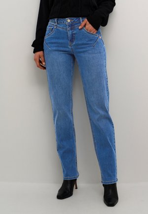 Blue denim jeans with a straight cut, front pockets, and subtle stitching details. Worn with black ankle boots and a dark sweater.