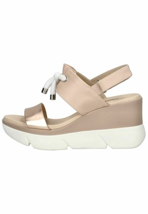 Sandalo zeppa beige con suola bianca spessa, cinturino metallico sulla punta, cinturino posteriore regolabile e dettaglio in pizzo bianco sul cinturino frontale.