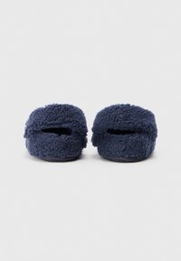 Zapatillas de casa esponjosas de color azul marino con una parte superior suave y texturizada. Diseño destalonado y base plana para un uso cómodo. Sin herrajes o acentos visibles.