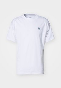Bílý bavlněný tričko s kulatým výstřihem, krátkými rukávy a subtilním šedým logem New Balance na levé straně hrudi.