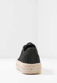 Espadrilla nera in rete con suola in juta intrecciata. Presenta una striscia metallica sottile e un pannello posteriore testurizzato per un dettaglio aggiuntivo.