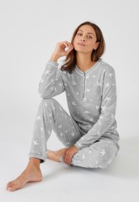 Conjunto de pijama gris que incluye una camisa con botones y pantalones estampados con siluetas de pájaros blancos. Tejido suave con una textura lisa.
