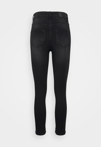 Jeans skinny pretos com um design de cinco bolsos, cintura alta e detalhes de costura subtil. O tecido possui uma textura suave e um formato ajustado.