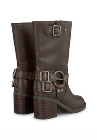 Botas de cuero marrón hasta el tobillo con punta cuadrada, tacón grueso, acentos de doble hebilla y correas texturizadas. Acabado suave con herrajes resistentes.