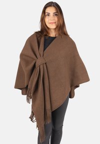 Brauner, Wollmischungs-Poncho mit Knotenschluss und fransigen Kanten, der elegant über die Schultern fällt. Die strukturierte Oberfläche verleiht Tiefe.
