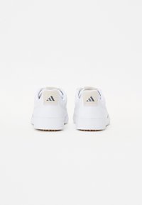 Vita sneakers med slät läder- och textilöverdel, texturerad beige hältapp och gummisula med små nubb för grepp. Tre ränder-logotyp.