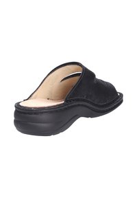 Schwarze Wildleder-Sandalen mit runder Zehenpartie, freiliegender Ferse und beigem Lederfußbett. Verfügt über eine niedrige, gepolsterte Gummisohle mit Nähdetails.