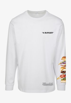 Chemise blanche à manches longues avec le texte "A BURGER" sur la poitrine, des instructions détaillées de montage de burger près de l'ourlet, et un graphique de burger empilé sur la manche.