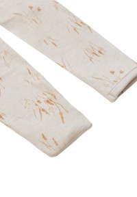 Leggings en tissu beige avec un subtil motif de blé en marron clair. Le matériau est doux, avec une texture lisse et des poignets repliés.