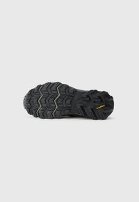 Juodas tvirtas batų padas su giliomis struktūromis ir Goodyear logotipu ant kulno, sukurtas lauko sukibimui ir ilgaamžiškumui.