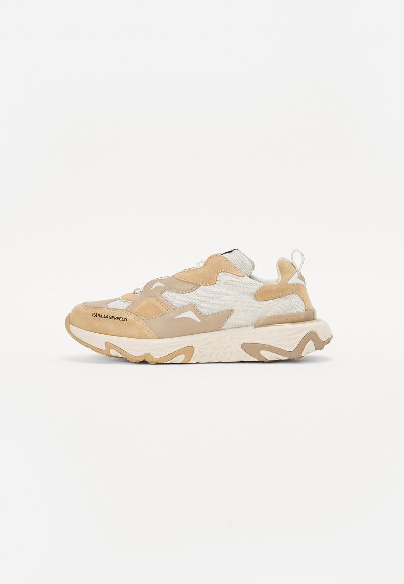 Beige un krēmkrāsas sporta apavi ar audumu kombināciju, kas sastāv no zamšādas un sieta, ar masīvu zoli un teksturētām akcentiem. Logo sānos.