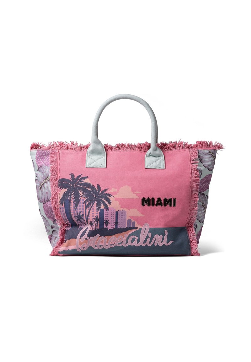 Bolso tote rosa con bordes flecos, que presenta gráficos de palmeras y un horizonte de ciudad, texto "MIAMI" y lados con patrón floral. Material duradero.