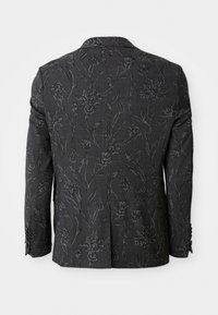 Blazer gris foncé avec texture florale, présentant un design légèrement en relief, des épaules structurées et des détails de poignet à quatre boutons.