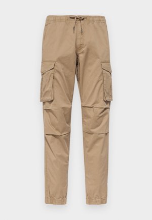 Pantaloni cargo beige in cotone, con vita elastica e lacci, tasche laterali e gambe affusolate con orli risvoltati.