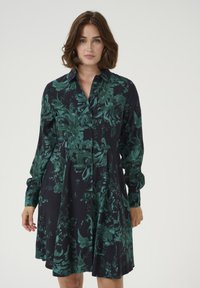 Langärmliges Kleid in Marineblau mit dunkelgrünem Blumenmuster, mit durchgehender Knopfleiste und ausgestelltem Rockdesign. Glatte Stofftextur.