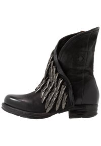 Svart läderankelboot med spetsig tå, utrustad med metalliska spetsaccen på sidan och en texturerad vikningdesign på toppen.