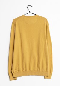 Senfgelbes Sweater aus weichem Strickstoff, mit rundem Ausschnitt, langen Ärmeln und gerippten Bündchen und Saum. Hängt an einem schwarzen Haken.