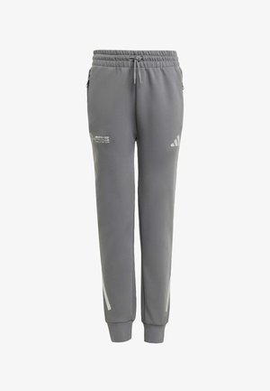 Šedé športové nohavice z textúrovanej tkaniny, vybavené elastickým pásom, šnúrkou na stiahnutie a bočnými logami s reflexnými akcentmi.