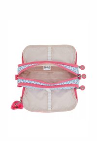 Kipling pink und blau gemusterte Reißverschlusstasche mit zwei Fächern, Stoffinnenraum und einem flauschigen pinken Charme, der angebracht ist.