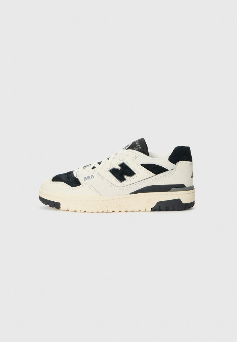 Baskets New Balance 550 blanches et noires vues de côté avec semelle crème et logo "N" noir sur un fond clair uni.
