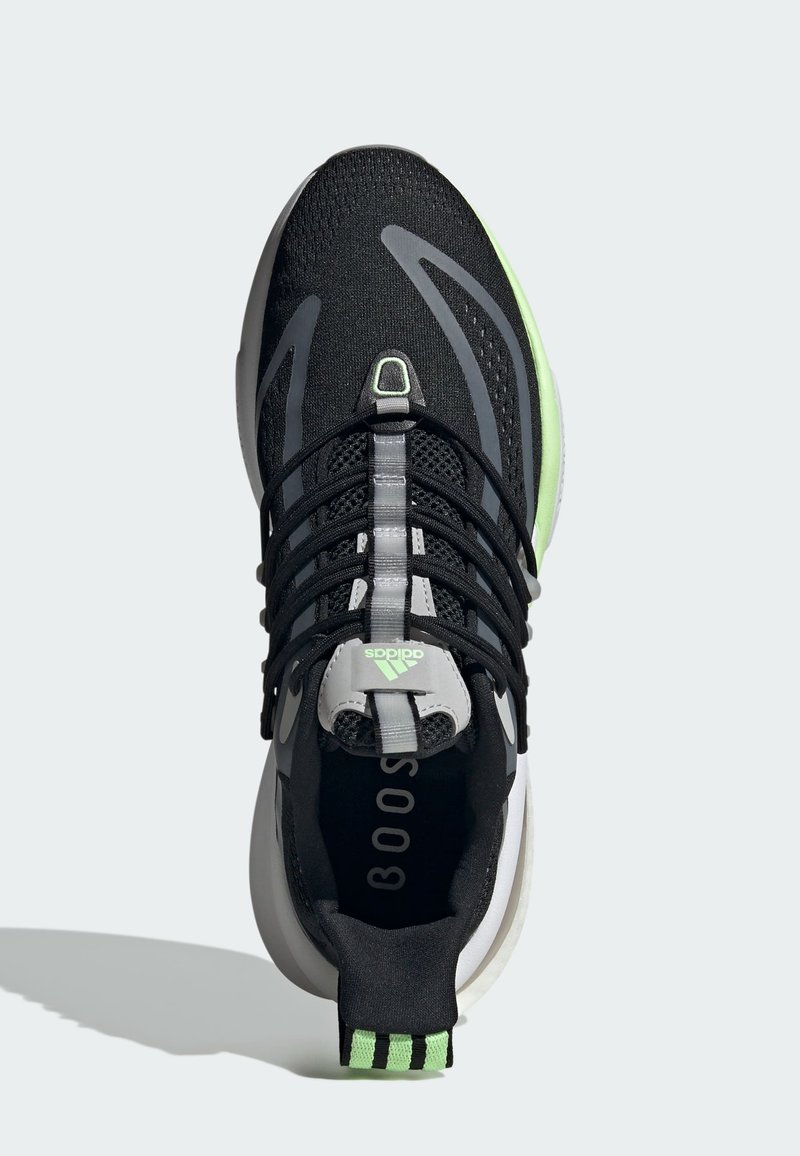 Botte de sport noire avec tige en mesh, accents gris, surbandes vertes et une semelle blanche épaisse. Présente un laçage proéminent et un logo à l'arrière.