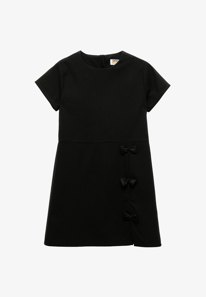 Vestido de algodón negro con mangas cortas, escote redondo y tres pequeñas lazadas en el costado. Silueta limpia y estructurada. Cierre de cremallera oculto en la parte trasera.