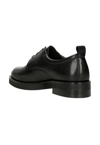 Scarpa oxford in pelle nera con punta arrotondata, texture liscia, design con lacci e suola in gomma bassa e spessa. Include un'apertura nella parte posteriore.