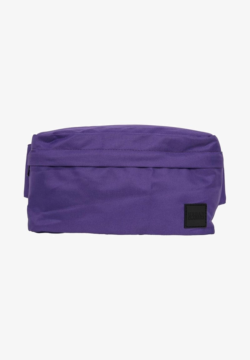 Sac banane rectangulaire en tissu violet avec une fermeture éclair et une petite étiquette noire en bas à droite.