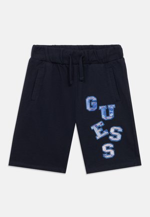 Shorts en coton bleu marine avec une taille élastique, ornés de lettres "GUESS" brodées colorées de tailles variées. Comprend des poches latérales.