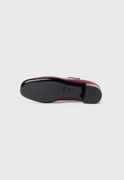 Scarpa in pelle verniciata bordeaux con finitura liscia, punta arrotondata e suola in gomma nera. Presenta un tacco basso e un branding minimale.
