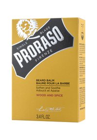 Proraso skäggbalsamets förpackning har en gul låda med en svart etikett, silverfärgade texter och en lejonillustration. Storlek: 100 ml, doft: trä och kryddor.