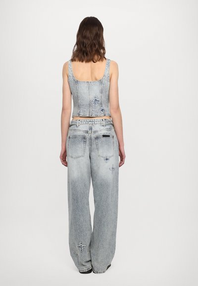 Denim crop top and wide-leg jeans in light wash, featuring contrasting stitching, decorative cross embroidery, and a relaxed fit.