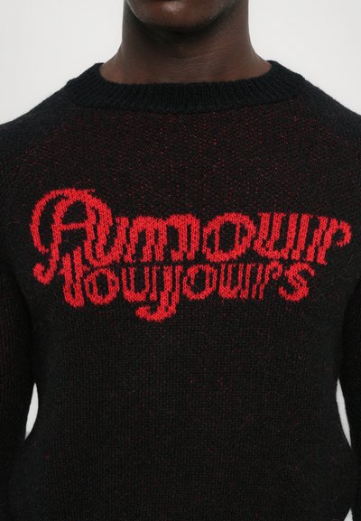 Pulover tricotat negru cu text roșu care spune "Amour Toujours." Guler cu textură ribbed și material texturat cu nuanțe subtile.