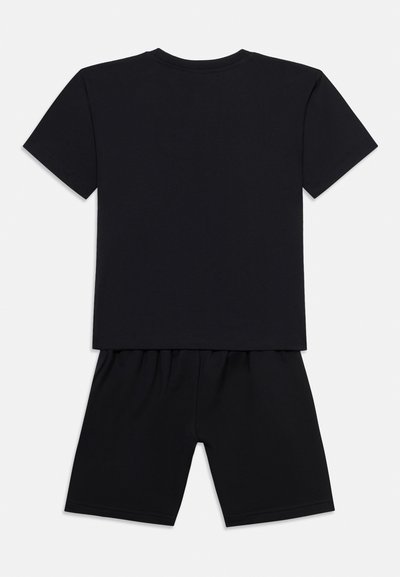 Μαύρο κοντομάνικο μπλουζάκι συνδυασμένο με μαύρο σορτς με ελαστική μέση, απλωμένα σε λευκό φόντο, εμφανίζοντας την πίσω όψη.