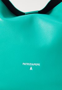 Türkiz színű bőrtáska texturált felülettel, fekete pánttal és fehér "PATRIZIA PEPE" logóval az alján. Zökkenőmentes forma.