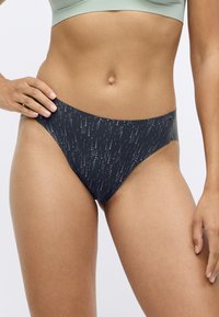Sötét tengerészkék bikini alsó, szétszórt ezüst pöttyös mintával, magas derekú szabás, elasztikus anyag, sima textúra és minimális takarású dizájn.