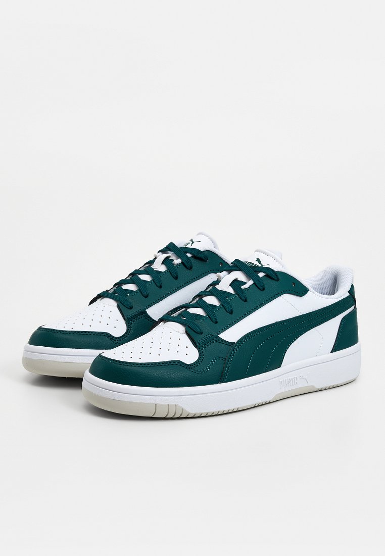 Zapatillas de deporte blancas y verde oscuro con una parte superior de cuero liso, puntera perforada, cuello acolchado y cordones planos. Suela de goma para agarre.