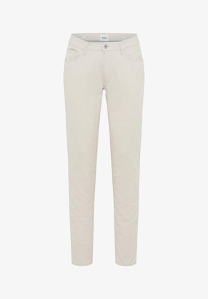 Pantaloni beige aderenti con tasche frontali, passanti per cintura, chiusura con bottone e etichetta del marchio Brax all'interno della cintura.