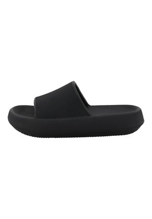 Sandale noire à semelle plate avec un dessus texturé et une semelle épaisse et lisse. Le design est minimaliste avec une large lanière pour le confort.