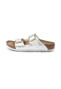 Sandales blanches à glissière avec deux bretelles réglables, semelle intérieure en liège et semelle en caoutchouc texturé. Présentent des boucles métalliques et un matériau supérieur lisse.